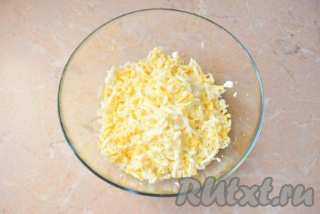 К луку добавьте натёртые на крупной тёрке яйца.