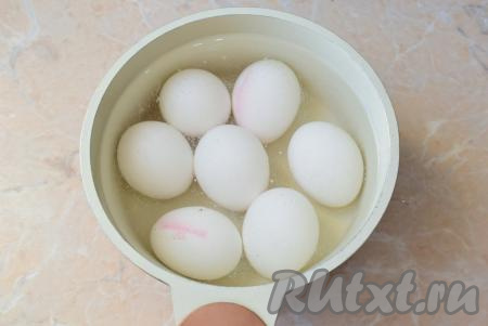 Для приготовления начинки отварите яйца в течение 7-8 минут  в кипящей воде, затем горячую воду слейте, остудите их в холодной воде и очистите.