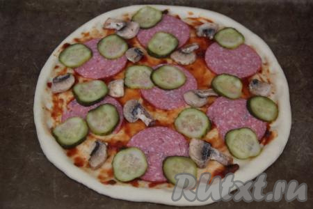 Свежие шампиньоны промыть, дать им немного обсохнуть, нарезать на пластины толщиной 3 мм (я взяла замороженные уже нарезанные на пластины шампиньоны, размораживать их не нужно), выложить рядом с колбасой. По желанию, можно добавить маринованные огурцы, нарезанные на тонкие кружочки.