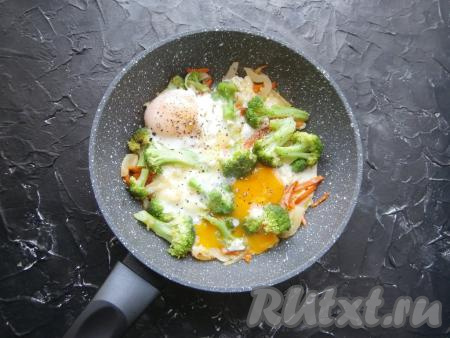 Готовить яичницу с брокколи под крышкой в течение 3-5 минут (до сворачивания белка). Блюдо поперчить.