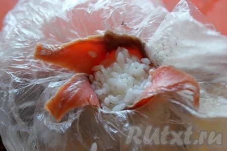 Влажными руками, смоченными в подкисленной уксусом воде, возьмите порцию - комочек риса и заполните подготовленное место.