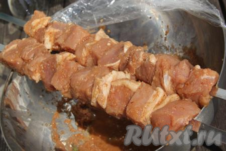 Нанизать кусочки свинины, замаринованные в вине, на шампуры.