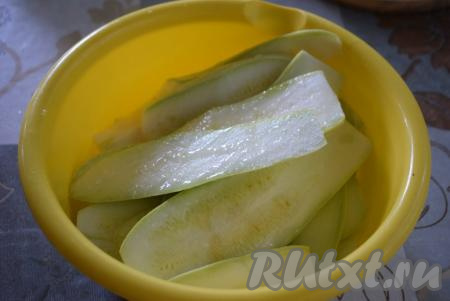 Молодые кабачки (с тонкой кожицей и мелкими семенами), не очищая от кожуры, нарезаем вдоль на пластины толщиной 4-5 мм. Складываем нарезанные кабачки в миску, посыпаем их солью и даём немного полежать. Сливаем с кабачков образовавшийся сок. Далее добавляем 0,5 столовой&nbsp;ложки&nbsp;растительного масла и руками растираем его по всей поверхности кабачков.