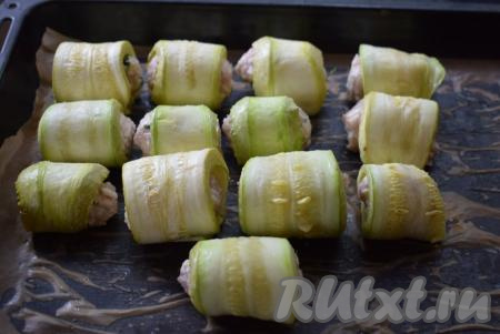 Выкладываем шарик из фарша на край более узкой стороны пластины из кабачка и сворачиваем рулетик. Таким образом формируем все кабачковые рулетики с фаршем.