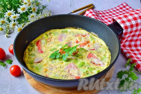 Омлет, приготовленный с кабачками и помидорами, получается очень вкусным, сытным и аппетитным, подавайте его в горячем виде.