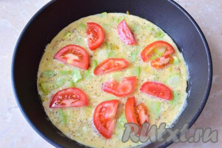 Помидор помойте, нарежьте достаточно тонкими полукружочками, разложите по поверхности омлета. Накройте крышкой сковороду и готовьте омлет с кабачками и помидорами на маленьком огне 5-7 минут (верх готового омлета не должен быть жидким).