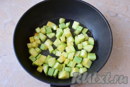 Разогрейте сковороду, затем налейте на неё немного растительного масла, выложите нарезанные кабачки и обжаривайте их на небольшом огне в течение 5-6 минут, периодически переворачивая. За это время кабачки станут мягче и немного начнут подрумяниваться.