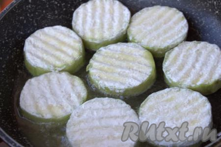 Обвалять кружочки кабачка со всех сторон в муке, стряхивая лишнюю муку. В сковороду влить растительное масло, разогреть, выкладывать на сковороду кабачки в один слой.