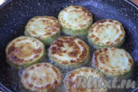 Обжаривать кружочки кабачков с двух сторон до золотистого цвета на среднем огне (примерно, по 2-3 минуты с каждой стороны), в конце жарки слегка посолить. Обжаренные кабачки переложить на тарелку. Обжарить аналогично все кабачки.