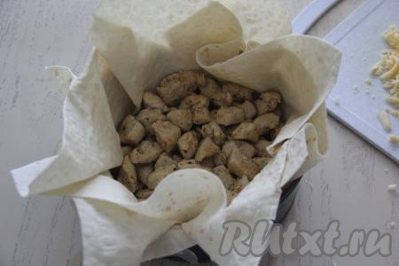 Выложить на дно формы с лавашом обжаренную курицу.