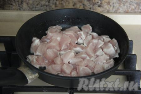 В разогретую сковороду влить растительное масло и выложить кусочки курицы.