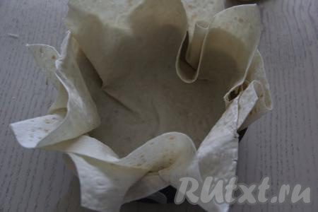 Разъёмную форму (у меня диаметром 24 см)&nbsp;выстелить лавашом. Для этого из лаваша вырезать 2 квадрата и выстелить ими форму, края лаваша должны свисать.