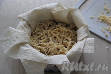 Сыр натереть на тёрке. Присыпать курицу половиной натёртого сыра.