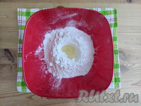 В центре горки из муки сделать углубление. Влить в это углубление растительное масло.