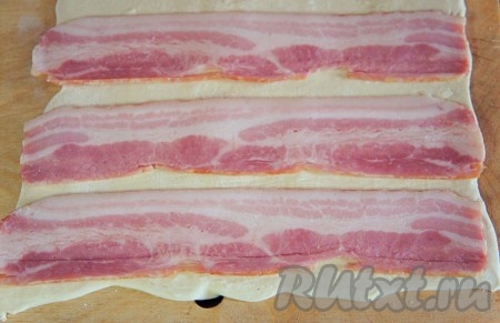 На тесто выложить полоски бекона.