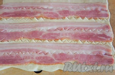 Разрезать тесто с беконом на полоски. 