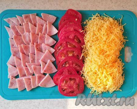 ​​​​​​Пока выпекается основа, подготовить начинку для пиццы.&nbsp;Помидор нарезать кружочками, ветчину (или варёную колбасу) - сегментами, сыр натереть на&nbsp;мелкой тёрке.