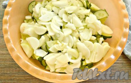 Очищаем репчатый лук. 0,5 килограмма очищенного лука нарезаем полукольцами и сразу добавляем к огурцам.