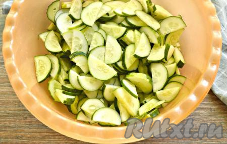 Подготовим нужные ингредиенты по списку. Вес указан после очистки овощей. Итак, промываем хорошо огурцы, срезаем хвостики с двух сторон. Нарезаем 2,5 килограмма подготовленных огурцов в широкую миску полукружочками (или кружочками).