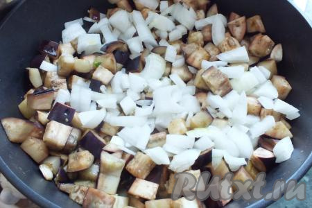 В жаровне (или в сковороде&nbsp;с толстым дном) разогрейте растительное масло, выложите баклажаны и, помешивая, обжарьте на умеренном огне в течение 5-7 минут (за это время баклажаны немного "осядут"), затем добавьте нарезанный лук. Обжаривайте, помешивая, в течение 7-10 минут.