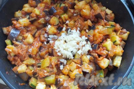 Затем добавьте измельчённый чеснок, перемешайте, прикройте крышкой, тушите овощной салат 7 минут.