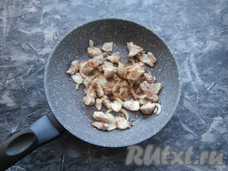 На достаточно сильном огне обжарить свинину с луком, помешивая, в течение 3-4 минут. Всыпать специи, соль и молотый чёрный перец.