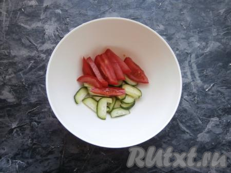 В глубокую миску (или тарелку) огурец нарезать тонкими полукружочками, помидор - дольками.