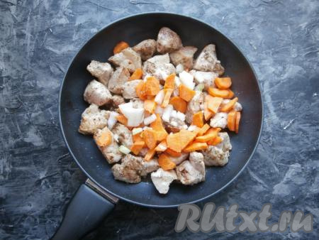 Обжарить кусочки свинины со всех сторон до лёгкой румяности на среднем огне, затем добавить нарезанный произвольно репчатый лук и нарезанную полукружочками морковку.