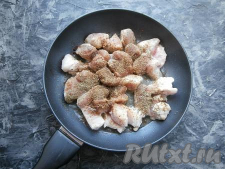 Кусочки мяса посыпать хмели-сунели, приправой, чёрным молотым перцем и кориандром.