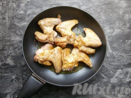 Обжарить куриные крылышки на растительном масле до лёгкой румяности с двух сторон на среднем огне.