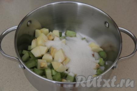 В кастрюлю, в которой будете варить компот, выложить ревень и яблоко, всыпать сахар.
