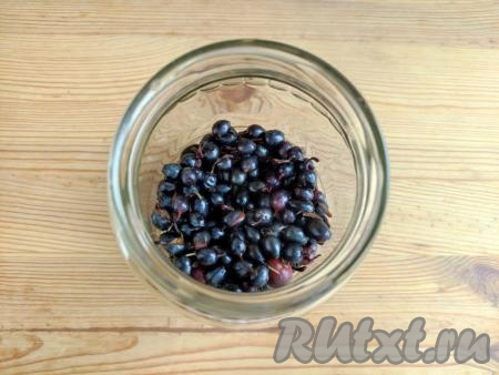 Банку объёмом 750 мл вымыть горячей водой с содой и простерилизовать над паром (или в микроволновке). Крышку для закрутки прокипятить в течение 3 минут, капроновую крышку для слива сиропа ошпарить кипятком. Чёрную смородину выложить на дно подготовленной банки.