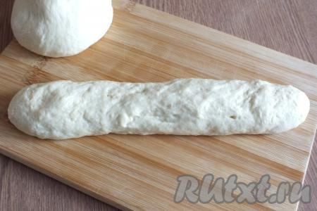 Смажьте руки растительным маслом. Разделите тесто на две части. Каждую часть подкатайте в жгут длиной 25-30 см.
