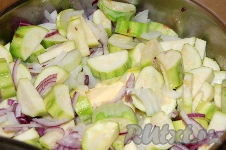 Нарезать репчатый лук обоих видов. Добавить лук к кабачкам в сковороду.