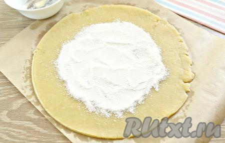 Охлаждённое песочное тесто выкладываем на пергамент и раскатываем в круг толщиной 3-4 мм. У меня получилась основа диаметром около 25 см. Можно подравнять края с помощью крышки или тарелки. Крахмал перемешиваем с сахаром. Получившуюся смесь распределяем по тесту, отступая от края по 3 см (как на фото).