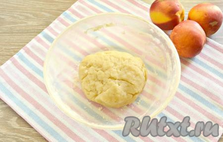 Быстро перемешиваем смесь с мукой, собирая в комок. Далее переносим тесто на стол, присыпанный мукой. Тесто будет горячим, но терпимо. Замешиваем песочное тесто. Возможно, потребуется ещё немного муки. Тесто получается в меру тугим, оно не должно прилипать к ладоням.