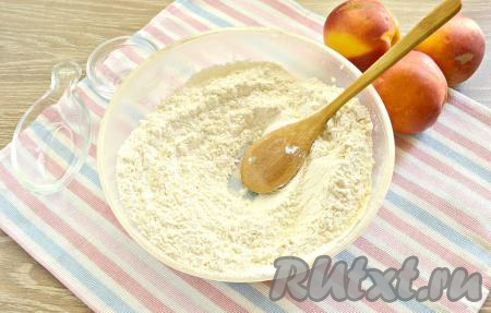 К муке добавляем соль и разрыхлитель, перемешиваем, формируя в центре мучной смеси углубление.