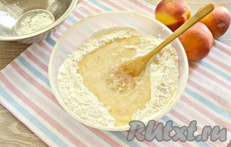 В небольшую кастрюльку (или ковшик) вливаем 70 мл кипящей воды и растительное масло, доводим на умеренном огне до кипения. Как только смесь слегка начнёт «булькать», переливаем её в углубление в мучной смеси.