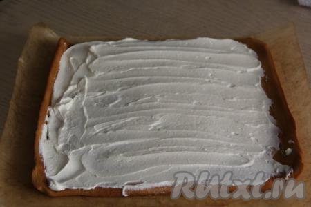 Смазать медовый корж творожно-сливочной начинкой. Свернуть корж, смазанный начинкой, в плотный рулет. 