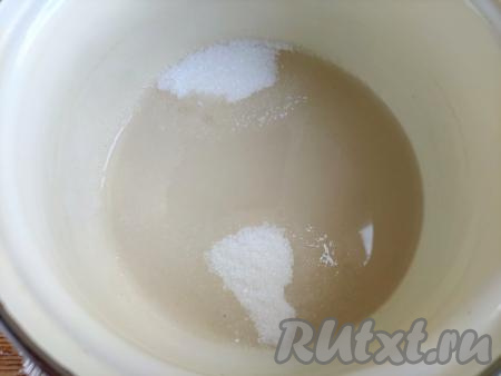 В кастрюлю с сахаром влить 50 мл воды, поставить на небольшой огонь, довести сироп, постоянно помешивая, до кипения и полного растворения сахара.