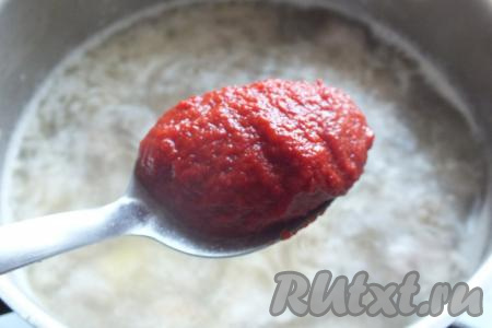 В кастрюлю с фаршем, обжаренным с картошкой, влейте 1,8-2 литра кипящей воды, добавьте очищенный и разрезанный на две половинки зубчик чеснока, проварите 15 минут. А затем извлеките чеснок, чтобы у супа не было горького привкуса. После того как уберёте чеснок, добавьте томатную пасту, перемешайте, доведите до кипения, убавьте огонь и варите 10 минут.