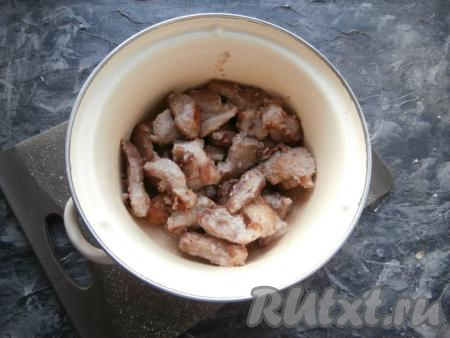 Обжаренные кусочки свинины переложить в кастрюлю.