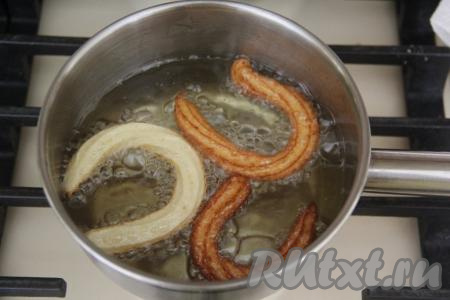 Масло для фритюра влить в сотейник и очень хорошо разогреть его. В раскалённое масло небольшими порциями отсаживать тесто из мешка в виде палочек или полуколечек. Жарить чуррос на умеренном огне до золотистого цвета со всех сторон.