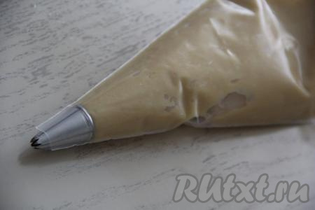 Переложить тесто в кулинарный мешок с тонкой, фигурной насадкой.