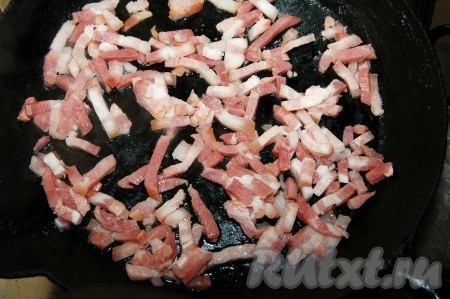 Бекон выложить на сковородку и обжаривать его на среднем огне, помешивая, до вытапливания жира (примерно, 10 минут).