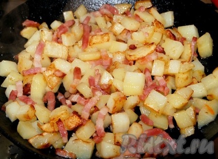 Перемешать, посолить, поперчить, снова перемешать и обжаривать картошку с беконом 5 минут.