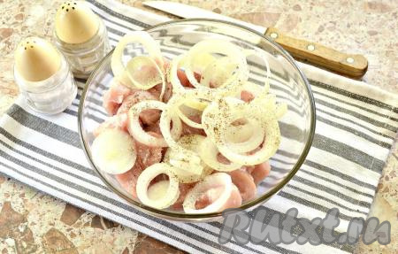 Кусочки свинины перекладываем в достаточно объёмную миску, в которой удобно будет мариновать мясо, добавляем очищенный и нарезанный кольцами лук, солим немного (сильно солить не нужно, в маринаде будет присутствовать соевый соус, а он и так солёный), перчим и сразу перемешиваем.