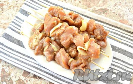 Замаринованные кусочки свинины, по желанию, чередуя с кольцами лука, нанизываем на деревянные шпажки. У меня вышло 5 шпажек (я их подогнала под размер сковороды) с 5 кусочками мяса на каждой. Возможно, шпажек потребуется больше, в зависимости от размера сковороды.