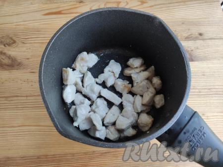 В кастрюлю с толстым дном влить растительное масло, нагреть его. Обжарить куриное филе в горячем масле на среднем огне до золотистого цвета со всех сторон, периодически помешивая.