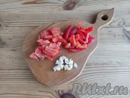 С помидоров снять кожицу, болгарский перец очистить от семян, с чеснока удалить шелуху, промыть овощи. Чеснок нарезать на тонкие пластины, а помидоры и перец - брусочками.